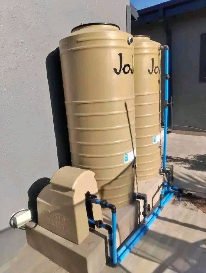 Water backup tanks connected to blue pipework and a pump enclosure